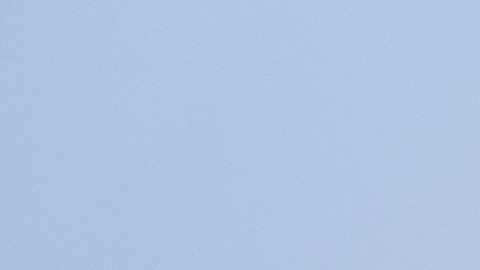 Chrysler Pacifica 2026 blanca frente a edificio histórico y banderas de Estados Unidos, minivan familiar estadounidense ideal para viajes urbanos y suburbanos.