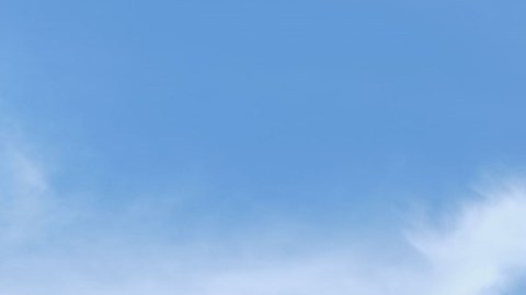 Dos sedanes Toyota Camry 2026, uno gris y otro azul, estacionados en una plaza adoquinada con árboles, quiosco y banderines bajo cielo despejado.