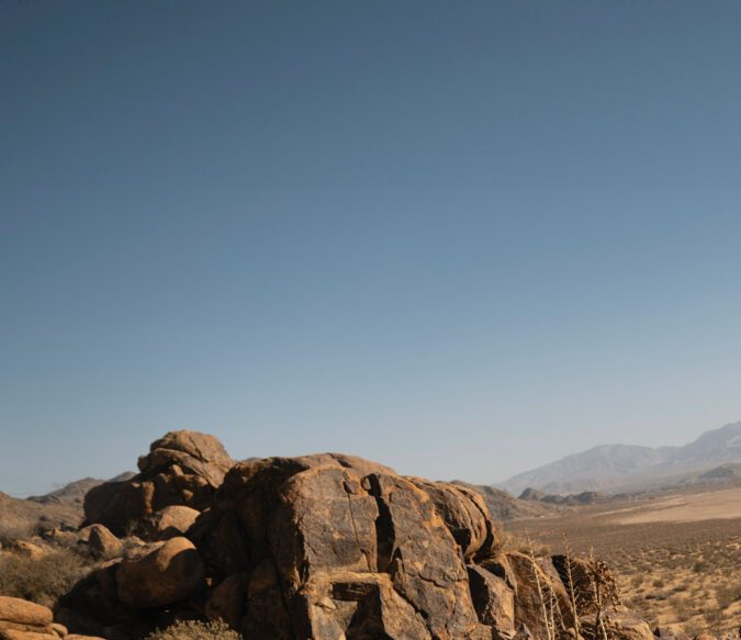 Toyota Tacoma Trailhunter 2026 gris subida en rocas, demostrando capacidades todoterreno y resistencia para aventuras extremas.​