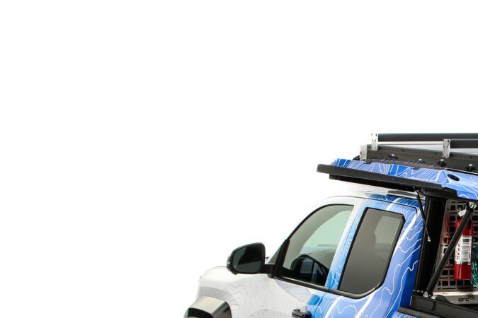 Parte trasera Toyota Tacoma H2 Overlander cerrada: Vista trasera de la Toyota Tacoma H2 Overlander con accesorios todoterreno y compartimientos de carga cerrados.