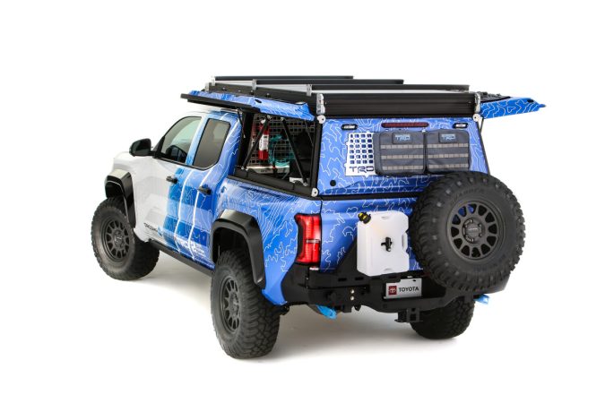 Parte trasera Toyota Tacoma H2 Overlander cerrada: Vista trasera de la Toyota Tacoma H2 Overlander con accesorios todoterreno y compartimientos de carga cerrados.