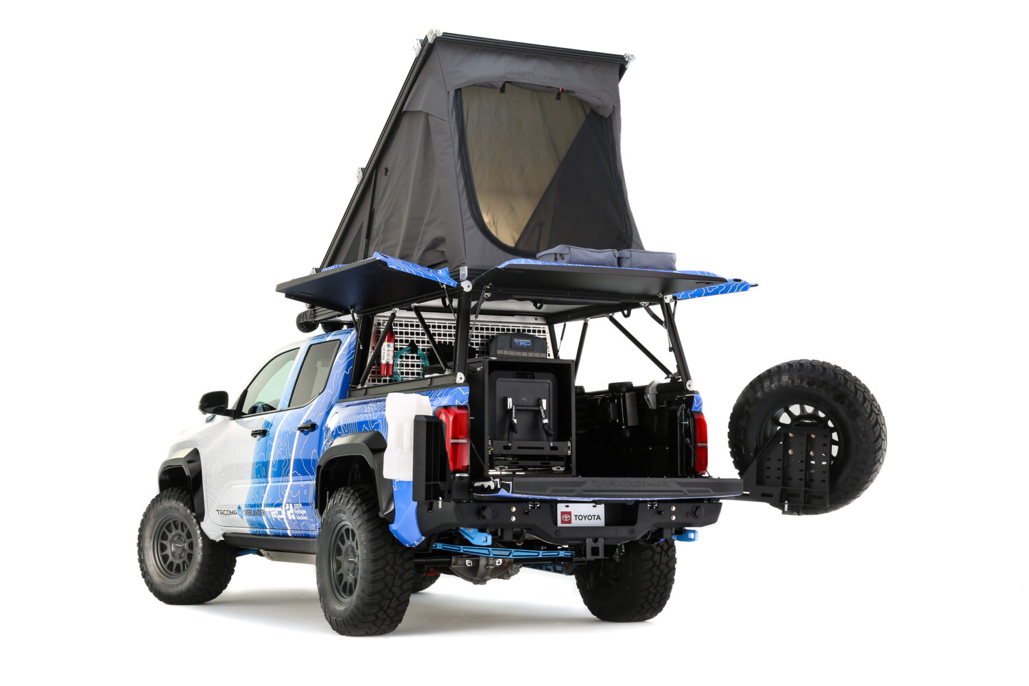 Pickup Toyota Tacoma H2 Overlander equipada con tienda de techo desplegable, ideal para aventuras off-road y acampadas.