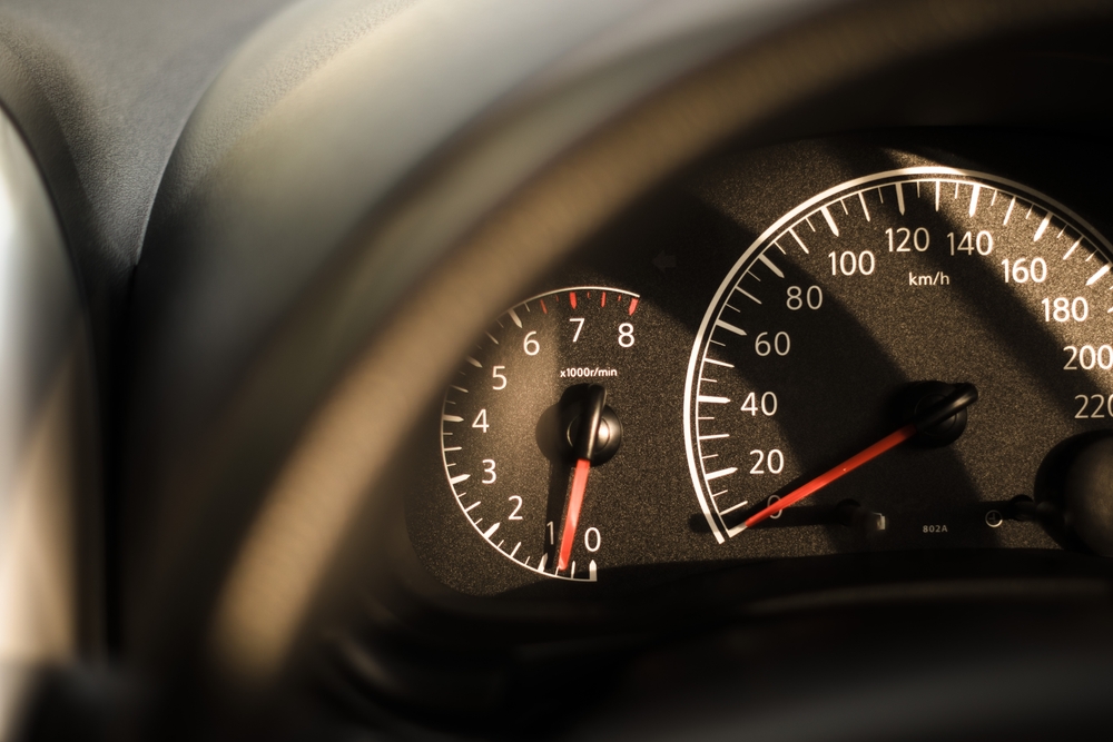 Velocímetro del coche durante el ralentí con la luz dorada del sol. Atascado en el concepto de tráfico.