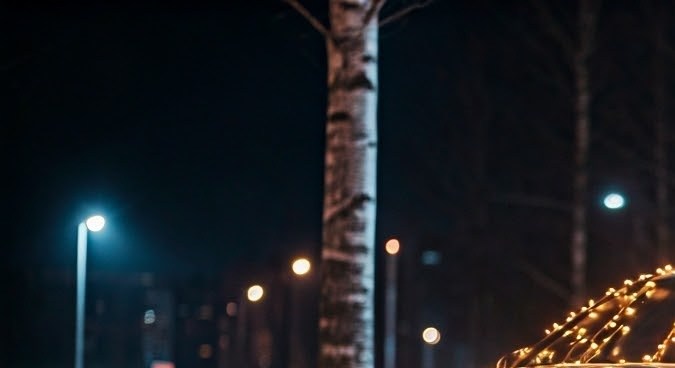 Coche moderno decorado con luces de Navidad, atardecer en el país nevado