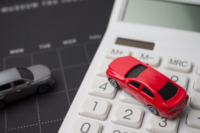 Toy cars model, black calendar and white calculator. Money financial management and calculation for buying car, car leasing, down payment, installment, auto insurance, service costs and so on concept.