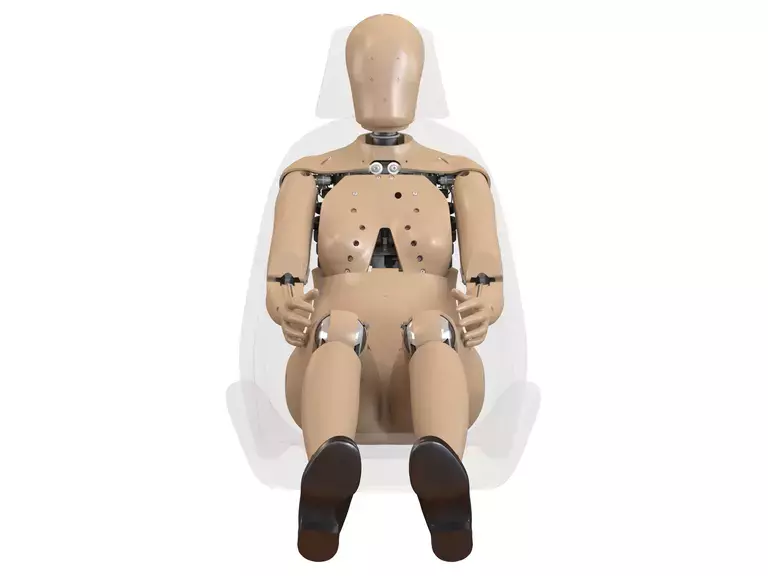 Vista frontal de crash test dummy femenino en asiento, usado para pruebas de impacto y desarrollo de autos más seguros para mujeres conductoras y pasajeras.