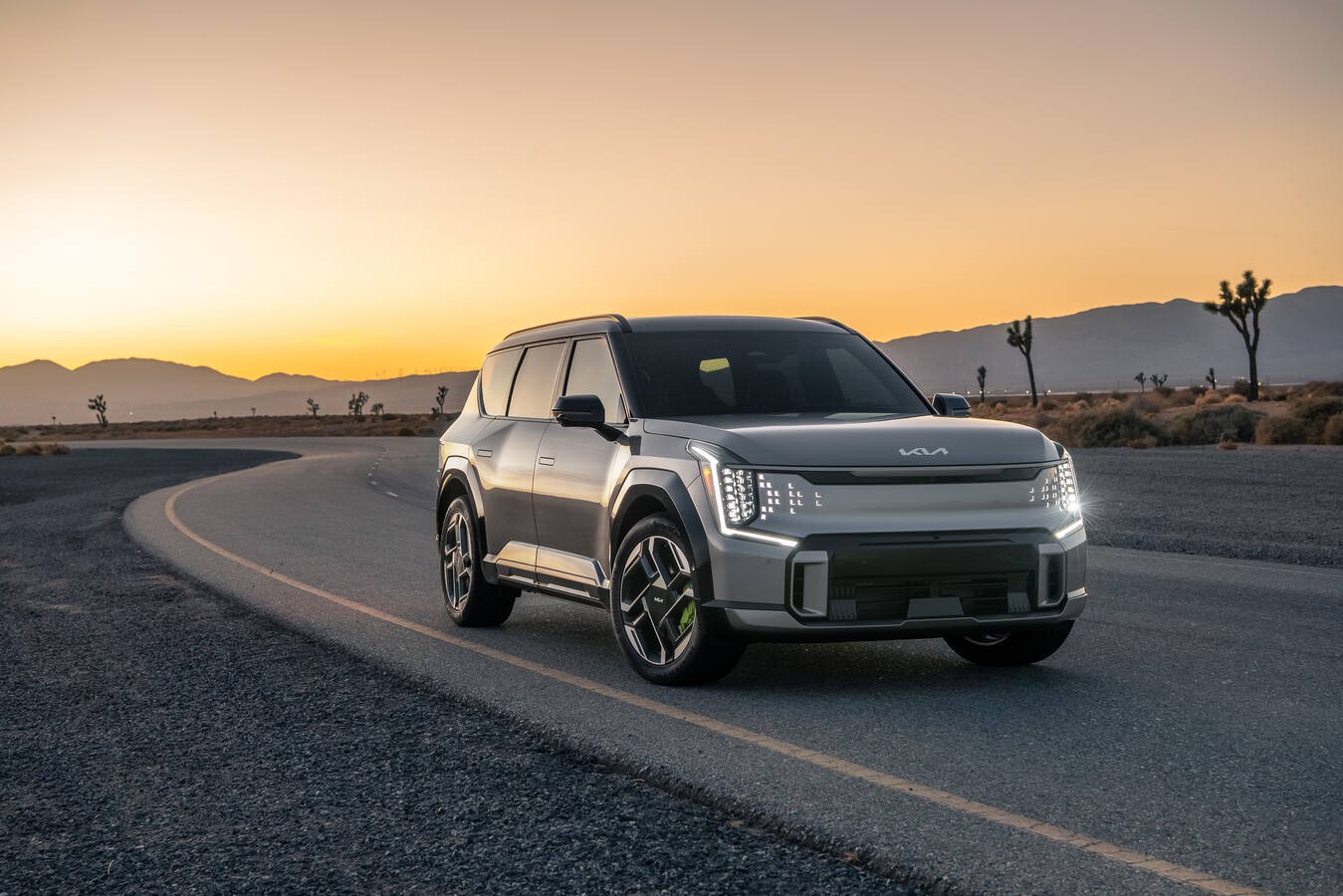 Kia EV9 GT 2026 en carretera al atardecer, SUV eléctrico de alto rendimiento presentado internacionalmente, diseño moderno y tecnología avanzada.