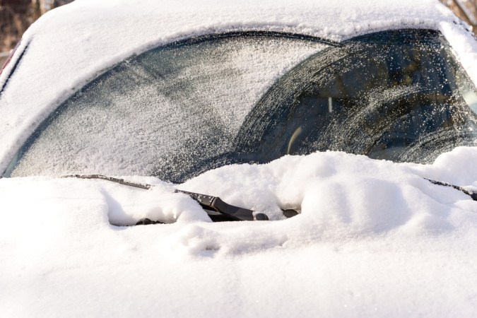 Pesada nieve cayó sobre el parabrisas de un auto durante el invierno