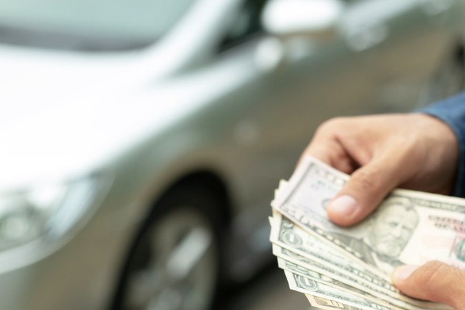 Empresario que tiene dinero en la mano camión delantero preparar el pago a plazos - seguro, préstamo y concepto de camión de compra concepto de financiación de camiones de seguros, préstamos y compras. compra y pago anticipado de un camión