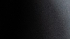 La mano de la persona se moja lijando un faro de coche para la restauración, pegado con cinta adhesiva verde.