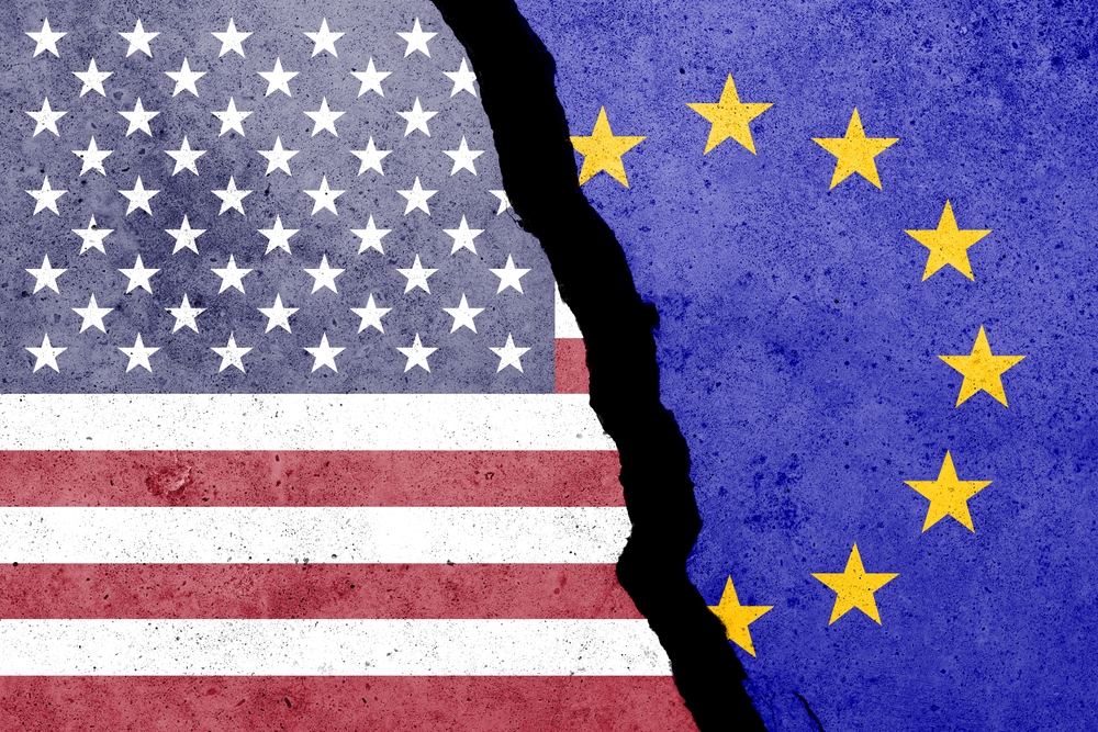 USA and EU flags painted on the concrete wall with word TARIFFS. Duty, trade, customs and tariffs war