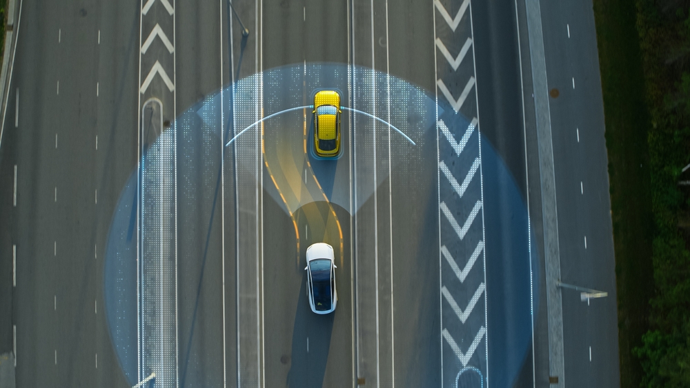 Vista aérea arriba abajo: Auto Autónomo Autoconducido Que Se Mueve Por La Ciudad, Pasando Por Otros Vehículos.