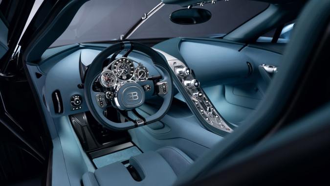 Interior minimalista Bugatti Tourbillon azul, tablero limpio casi sin pantallas, consola central metálica y asientos de cuero, lujo artesanal en hiperdeportivo exclusivo.