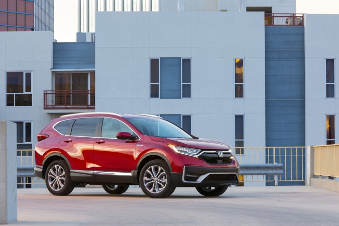 SUV Honda CR‑V Hybrid 2020 rojo estacionado en ciudad, vista lateral, mostrando diseño moderno y eficiente, ideal como SUV híbrido usado con buena relación calidad-precio.