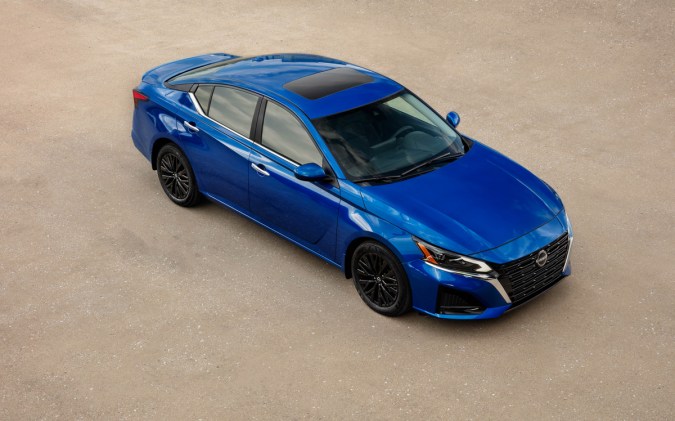 Nissan Altima azul 2025 visto desde arriba con techo panorámico, llantas negras y diseño deportivo estacionado sobre superficie clara.