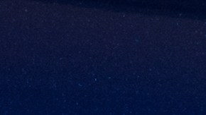 Emblema cromado ALTIMA sobre tapa trasera azul, junto a calavera roja, destacando logotipo del sedán Nissan.