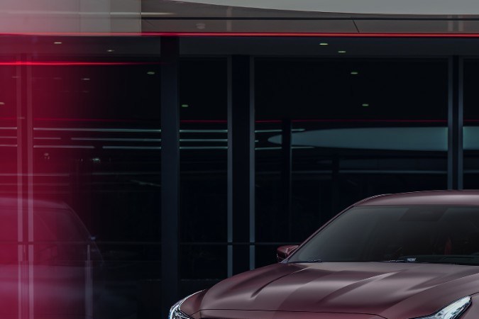 Cadillac CT5‑V Blackwing 2026 burdeos en escenario nocturno, sedán deportivo de alto rendimiento, parrilla agresiva y rines deportivos.