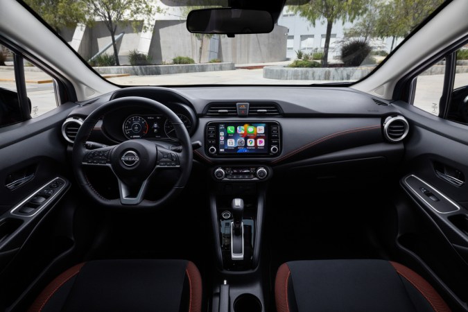 Interior del Nissan Versa 2025, detallando el tablero tecnológico, volante multifunción, pantalla táctil de infoentretenimiento y acabados de la cabina.