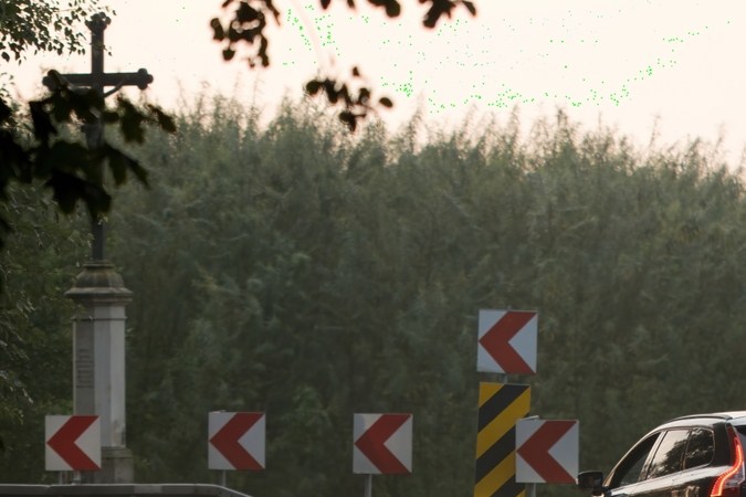 Un coche negro entra en un giro brusco durante el anochecer de principios de otoño, cruza en el fondo, la importancia de la conducción cuidadosa y la precaución en la carretera para evitar accidentes.