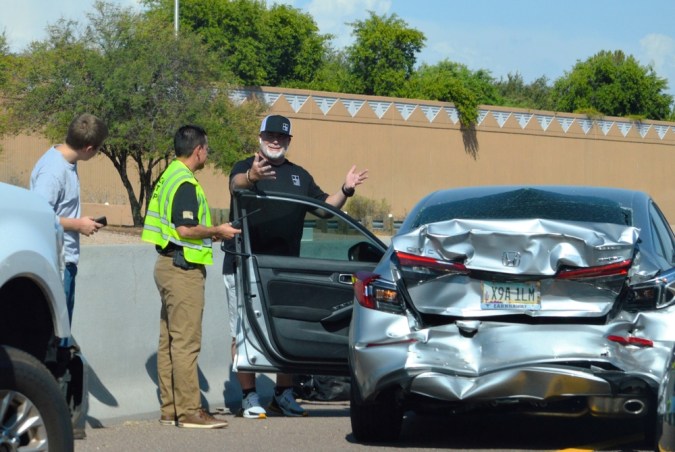 Conductores y personal de emergencia que sufren un accidente automovilístico en la autopista Loop 202 durante las horas punta.