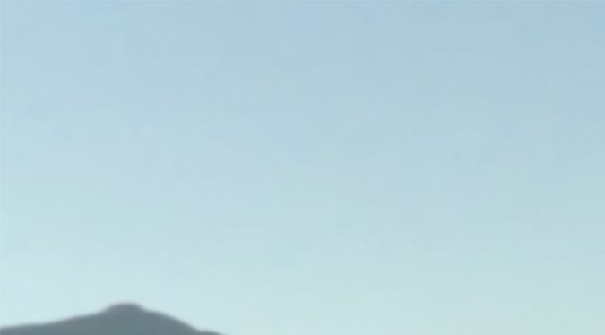 Ford Ranger PHEV blanca estacionada, vista frontal lateral, pickup híbrida enchufable 2026 en carretera de montaña, diseño robusto y moderno de Ford Ranger.