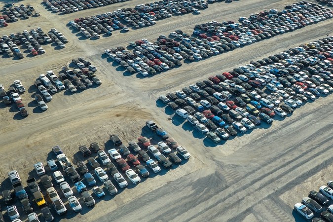 Coches dañados usados en el estacionamiento grande de la empresa Revendedor de subastas listo para los servicios de reventa. Venta de vehículos de segunda mano para título de reconstrucción o salvamento