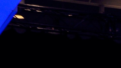 Ford Mustang Mach-E amarillo en exposición, certificado y destacado bajo luces en evento automotriz. Innovación y venta de autos usados Ford en Amazon.