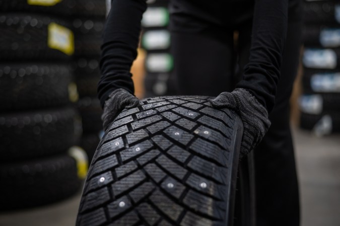 El mecánico mantiene las llantas de los coches con tachuelas en el garaje.
