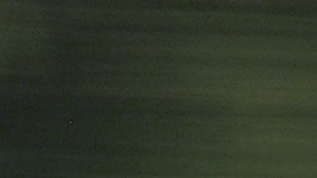 Toyota Camry 2005 plata en movimiento por autopista, sedán usado cómodo para viajes largos.