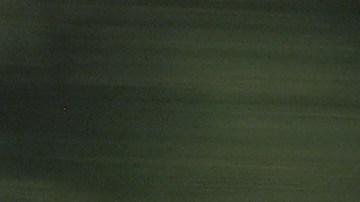 Toyota Camry 2005 plata en movimiento por autopista, sedán usado cómodo para viajes largos.