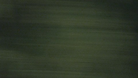 Toyota Camry 2005 plata en movimiento por autopista, sedán usado cómodo para viajes largos.