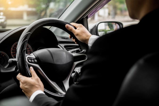 Retrato de un joven apuesto empresario conduciendo un coche deportivo de lujo