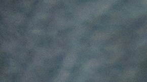 Una persona con guantes de punto azul enciende el calentador del asiento en un automóvil