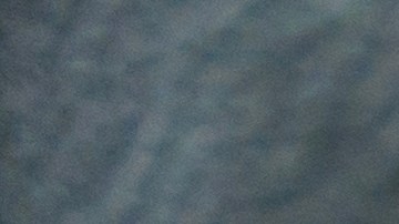 Una persona con guantes de punto azul enciende el calentador del asiento en un automóvil