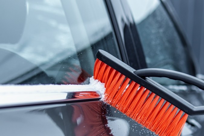 Limpiar el coche de la nieve con el cepillo. Enfoque suave. Cepillo especial para el coche