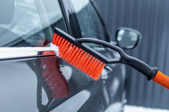 Limpiar el coche de la nieve con el cepillo. Enfoque suave. Cepillo especial para el coche
