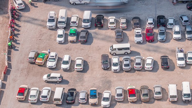 Vista aérea de coches completos en grandes aparcamientos exteriores en timelapse en Dubái, EAU. Oficinas y parque idénticos, congestión y aparcamiento lleno de otros coches, intenta entrar y salir, encontrar aparcamiento