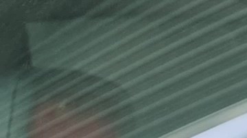 Padre joven que usa el cinturón de seguridad y mira a su hijo en el coche.