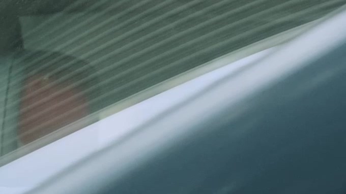 Padre joven que usa el cinturón de seguridad y mira a su hijo en el coche.