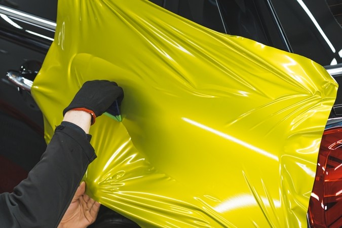 Embalaje de coche de vinilo utilizado por un especialista en detalles de coches profesionales para cambiar el color del coche negro.
