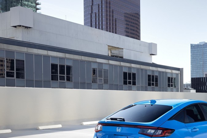 Vista lateral Honda Civic Sedan Sport Touring Hybrid 2025 azul, híbrido urbano elegante.