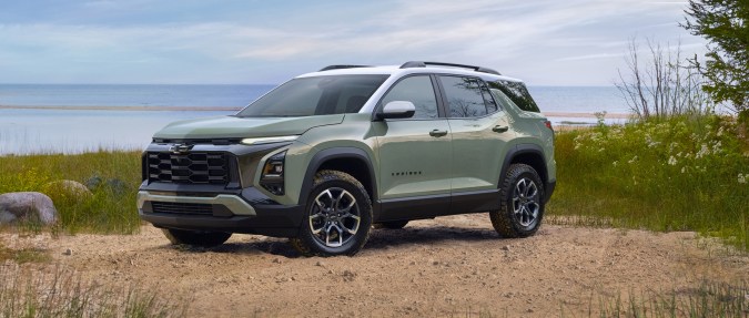 Chevrolet Equinox EV 2025 en verde junto al lago, SUV eléctrico con diseño robusto y techo panorámico.