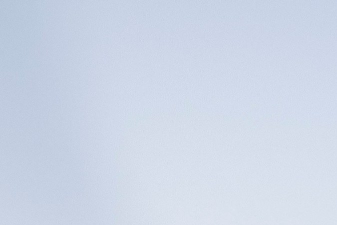 Primer plano parrilla y logo Chrysler Pacifica 2026 blanca, estilo audaz para minivan electrificable.