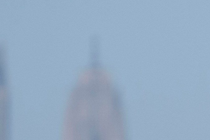 Chrysler Pacifica 2026 blanca frente a skyline y agua, minivan versátil para familias urbanas.