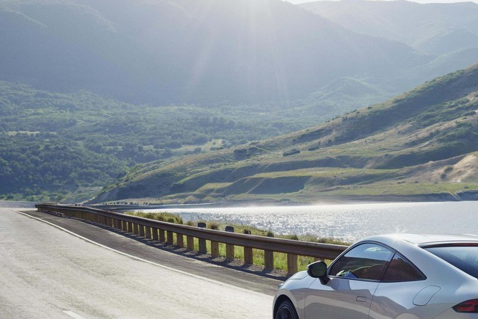 Honda Prelude 2026 blanco circulando junto al lago, coupé deportivo híbrido, perfecto para carretera, alto rendimiento, eficiencia y diseño aerodinámico para viajes largos.