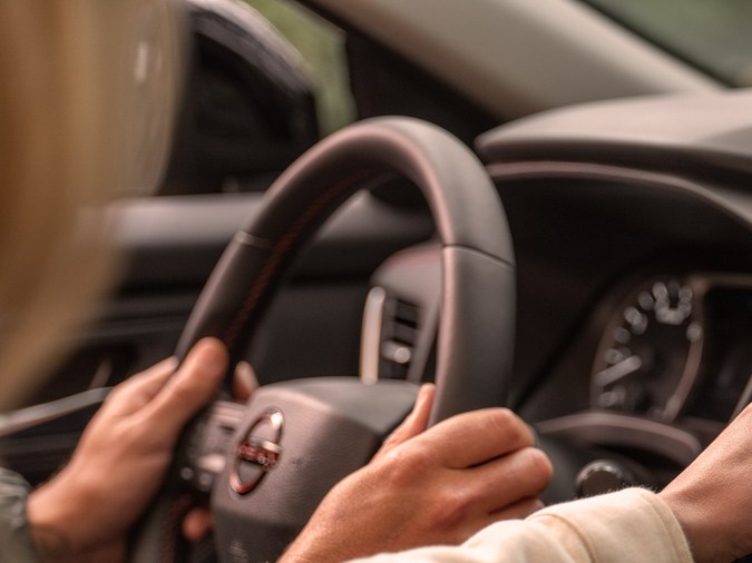 Nissan Rogue Rock Creek 2026 interior con mujer usando GPS, SUV Nissan 2026 conectividad y conducción moderna. ​