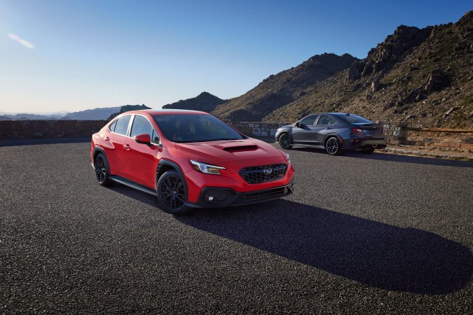 Subaru WRX 2026 rojo y gris estacionados en mirador de montaña, sedanes deportivos compactos con diseño robusto y enfoque en desempeño.