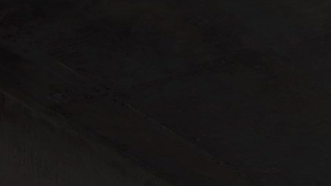 Toyota Crown 2026 plateado, vista trasera en estacionamiento moderno, auto híbrido fiable y duradero para uso prolongado.