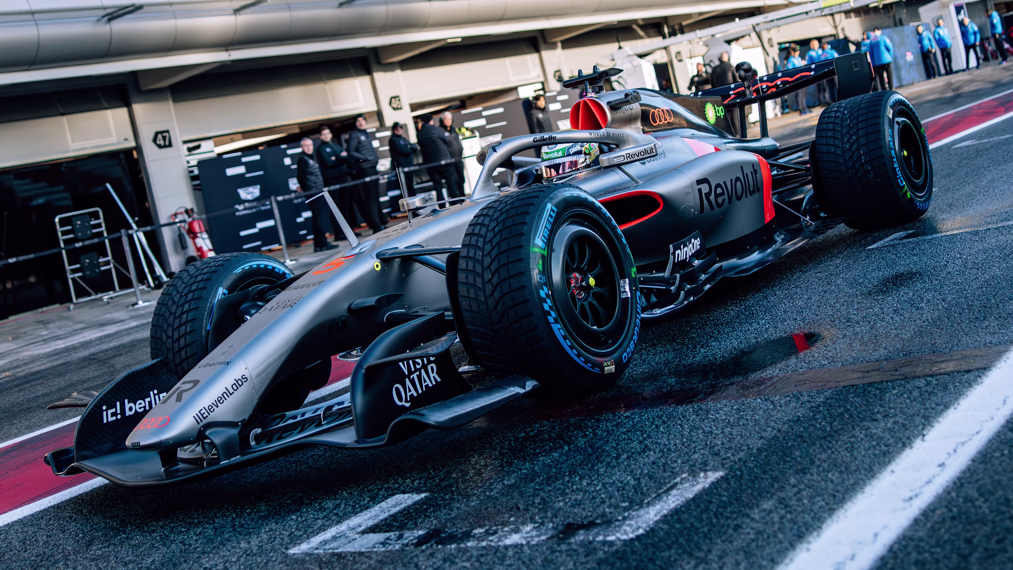Audi AF01 F1 2026 debut en Barcelona Shakedown, diseño negro plateado en boxes.
