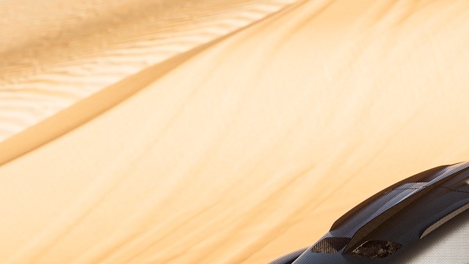 Genesis X Skorpio Concept en color negro trepando dunas en el desierto, con suspensión elevada, llantas todoterreno y diseño agresivo para off-road extremo.